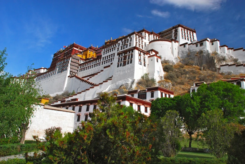 an ornate building is against the sky above trees