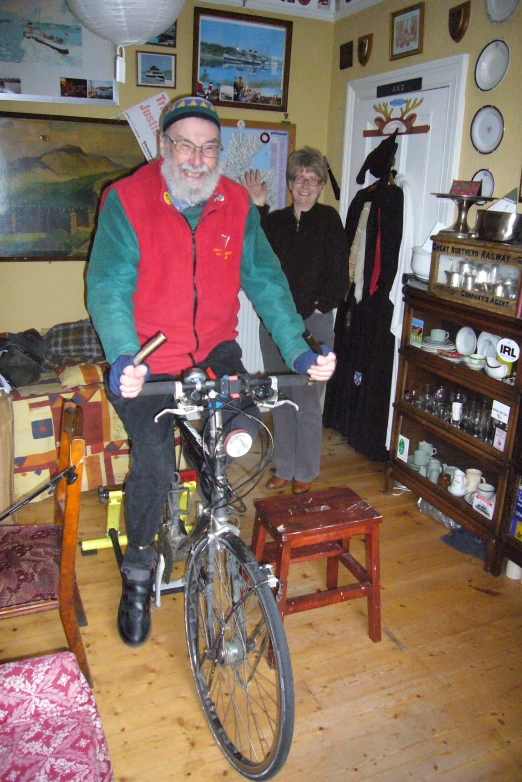 the man is riding a bike in a cluttered living room