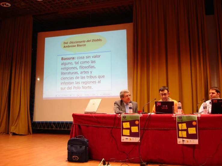 two people at a table in front of a projector screen