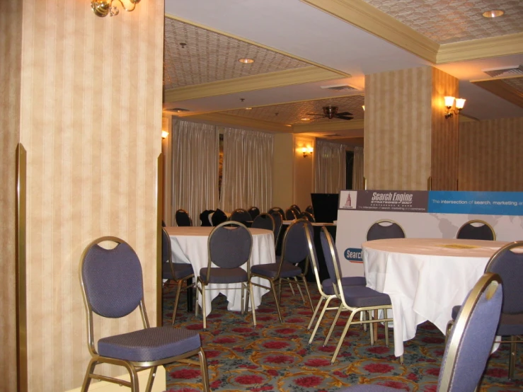 a room set up for a conference with blue and white chairs