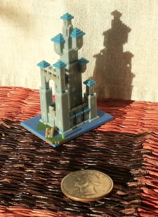 a coin next to a lego castle on a table