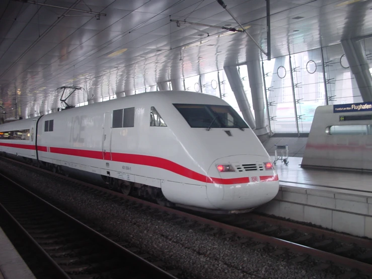 a modern train with red and white colors at a station