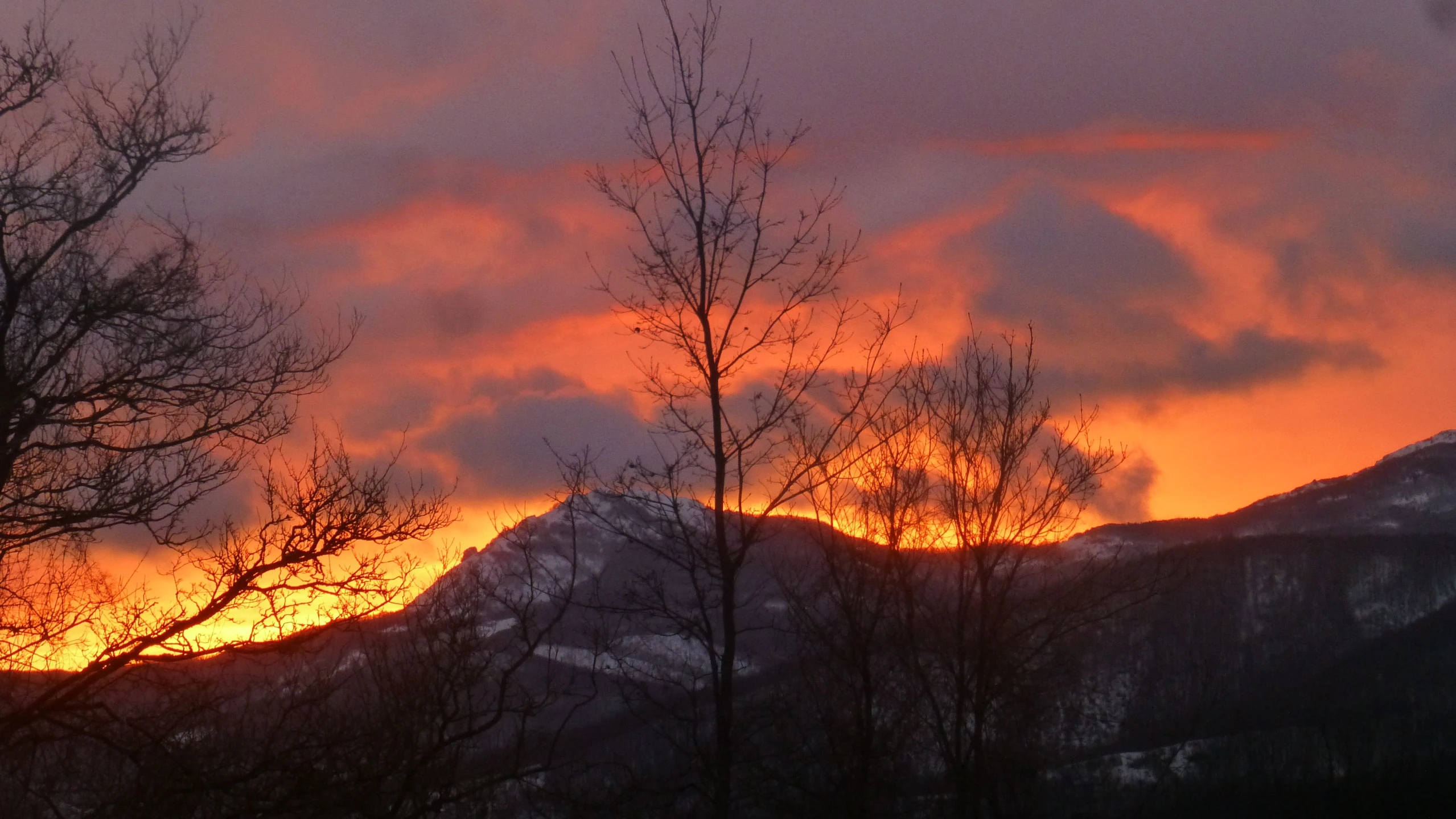 there are mountains on the hill as the sun is setting