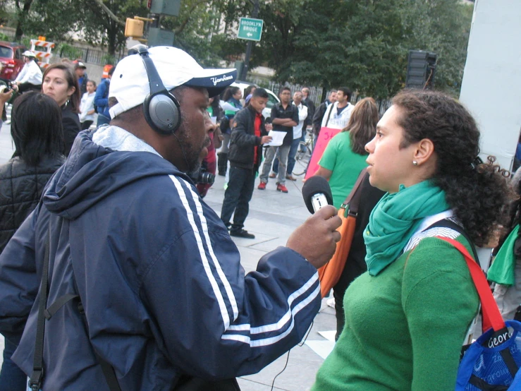 people are gathered around the street with headphones on