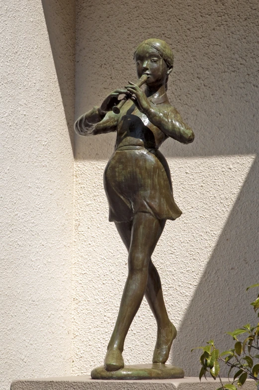 there is a bronze statue of a girl that is playing the violin