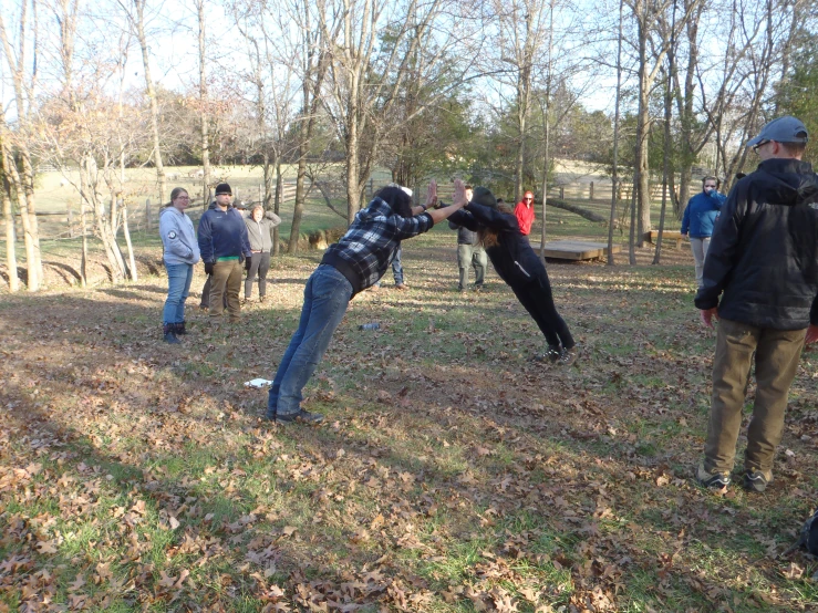 men standing in a field with one person throwing a bat