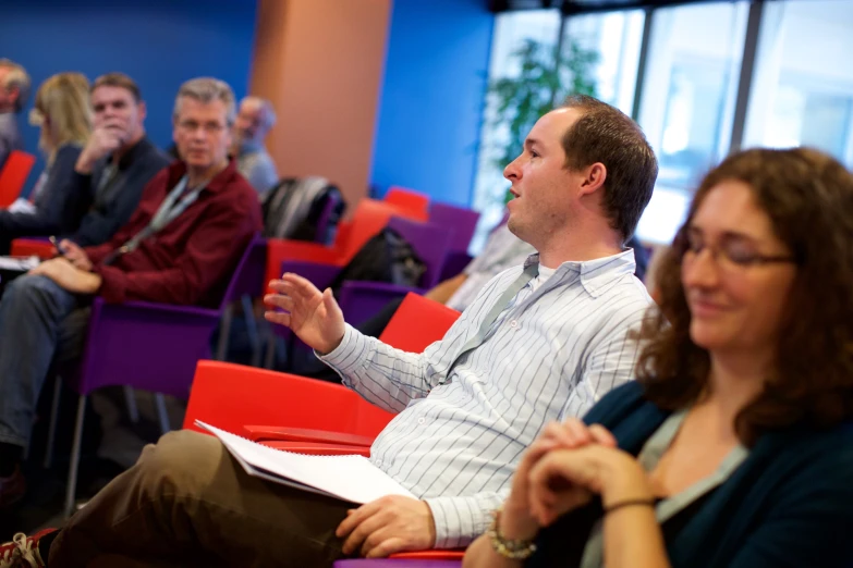 people sitting in chairs and taking a lecture