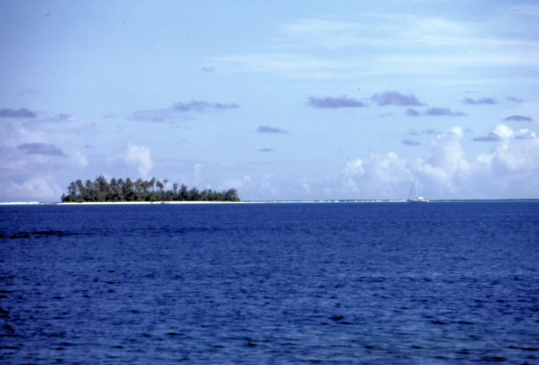 a lone island surrounded by calm ocean water