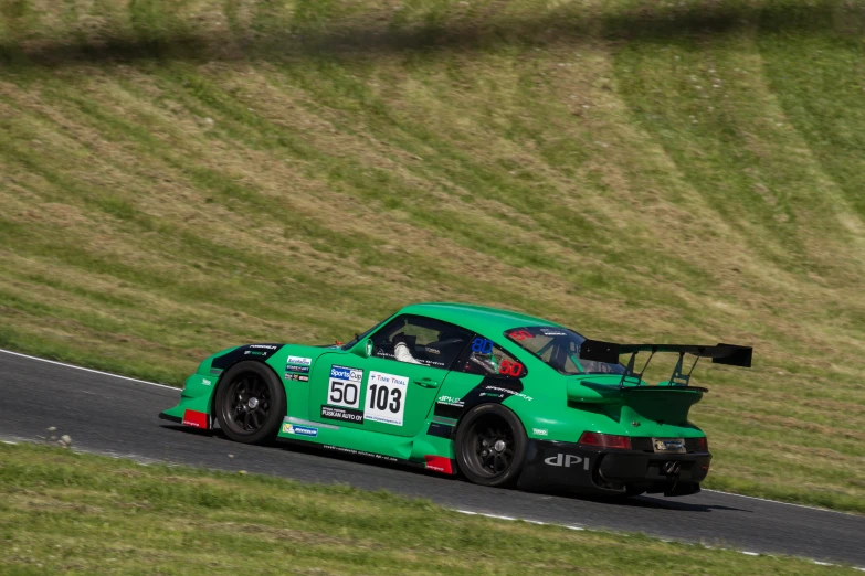 a green race car in the middle of the road