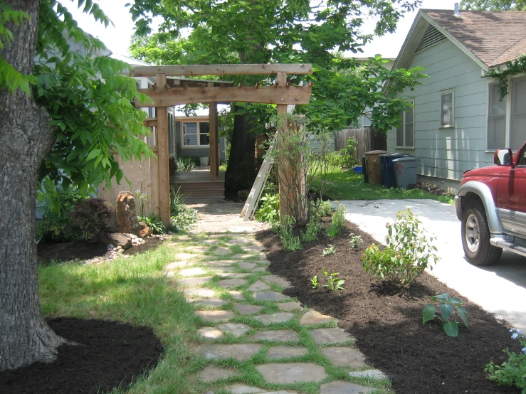 a garden with a walkway next to a house