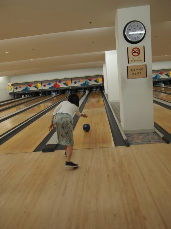 a boy in the bowling alley holding his bowling ball and trying to hit the pins