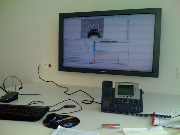 the computer screen is above the telephone and keyboard