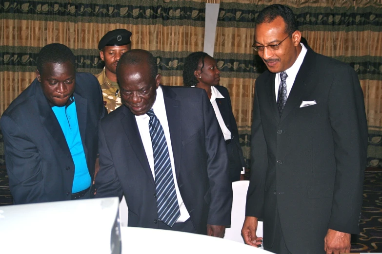 three men in business suits standing next to each other