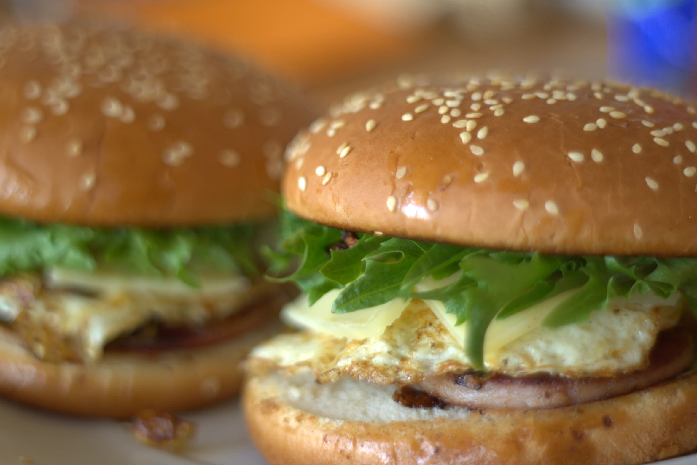 two sandwiches on a tray with egg and bacon