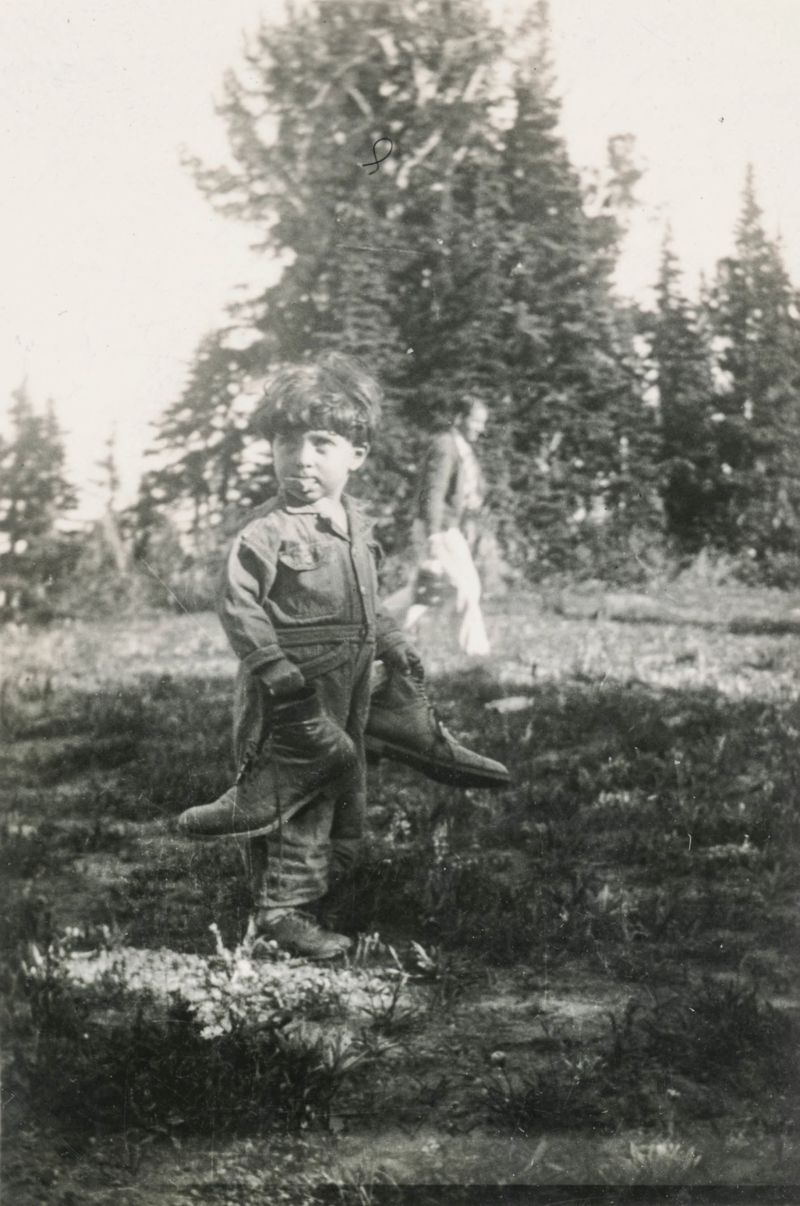 an old black and white po shows a person in work clothes standing next to a plane