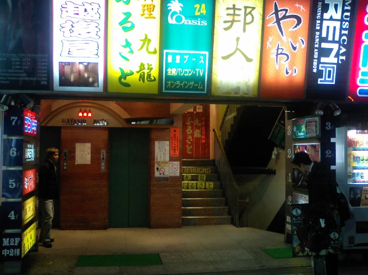 a doorway with various different lit up signs above