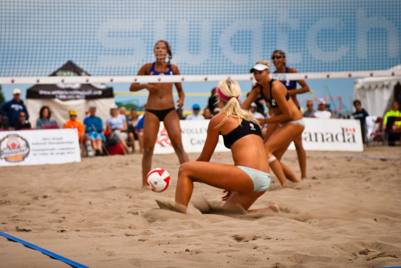 a group of women playing beach volleyball on the sand