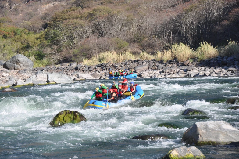 a raft is filled with several people riding it in rough water