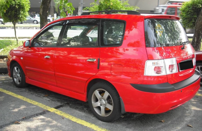 the small car is parked in the parking space near many other cars