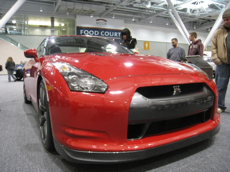 a red car with two silver wheels and an open door