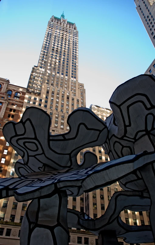 a sculpture in the city with tall buildings