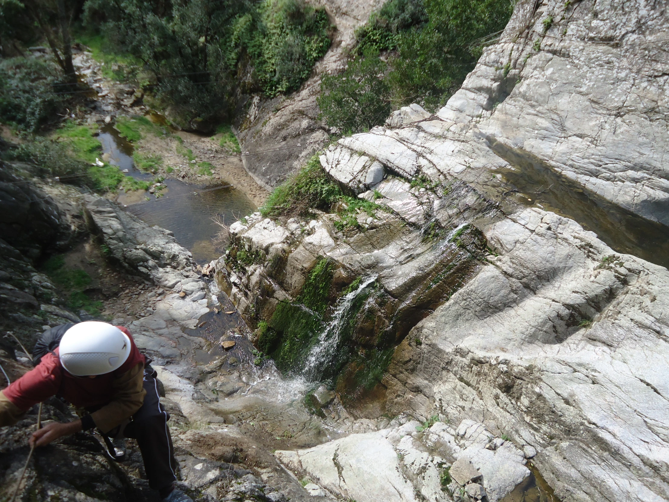 a man in red shirt climbing up a mountain slope