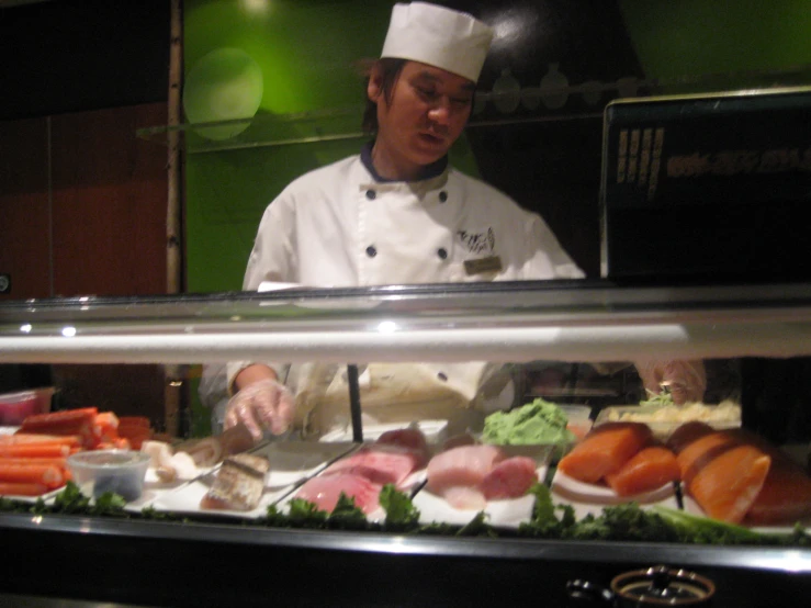 a chef prepares food behind a buffet line