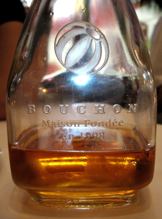 a large, clear glass bottle filled with liquor on top of a table