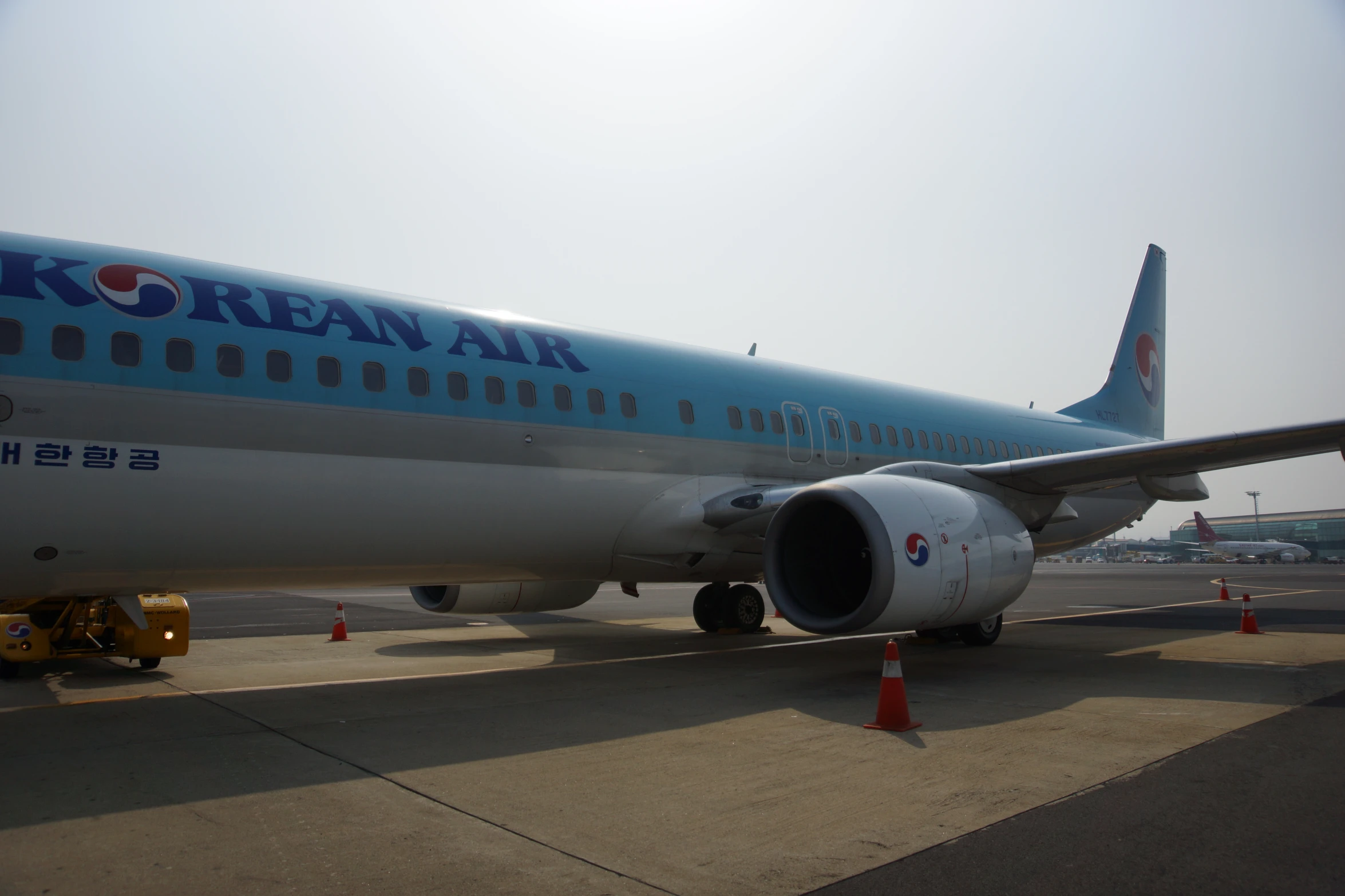 a large blue and white jet airplane on a run way