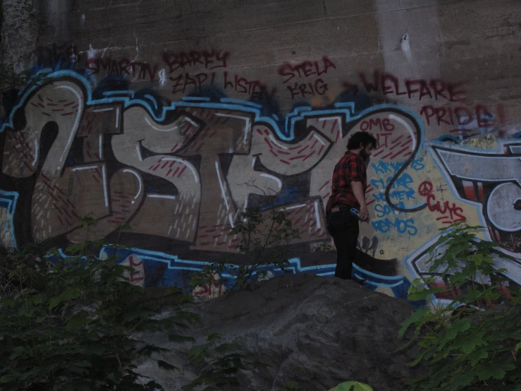 a young man looks up at graffiti written on the walls