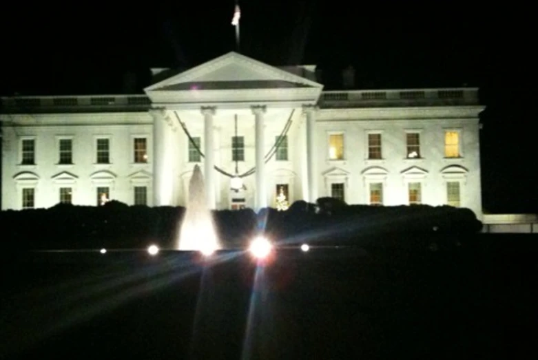 the lights on the fountain in front of a white building