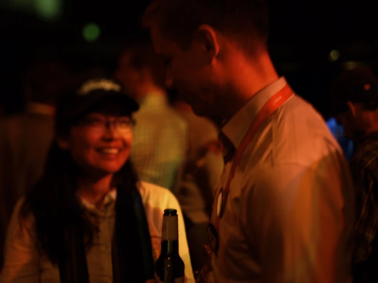 a man holding a bottle and smiling at a lady