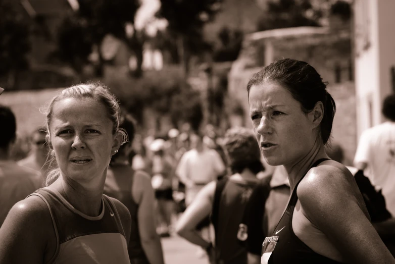 there are two women standing near a crowd