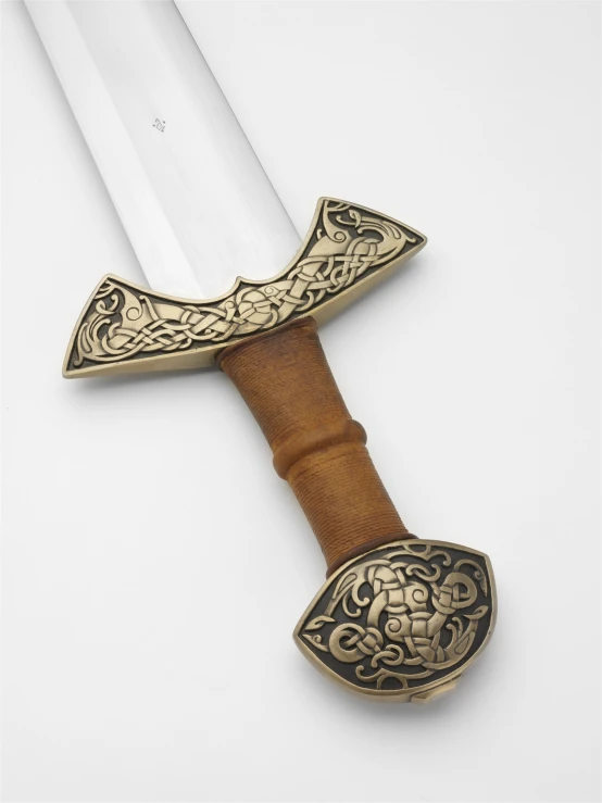a fancy decorated hand - made sword rests on the surface