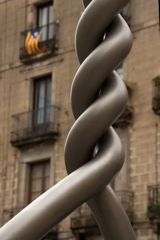 an interesting sculpture by some buildings near a large window