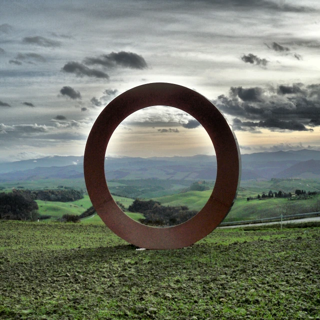 the sculpture is located in a lush green field
