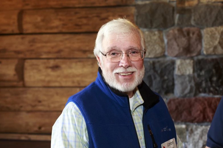 an older gentleman with white hair wearing glasses and vest