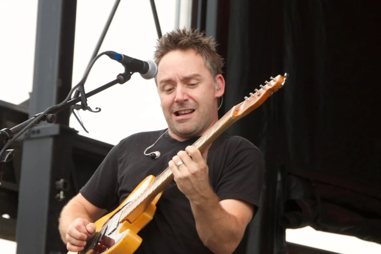 a man plays an electric guitar on a stage