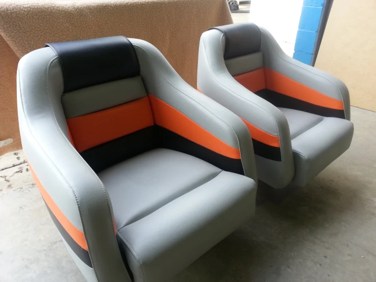 two gray and orange chairs with black leather upholstered on them