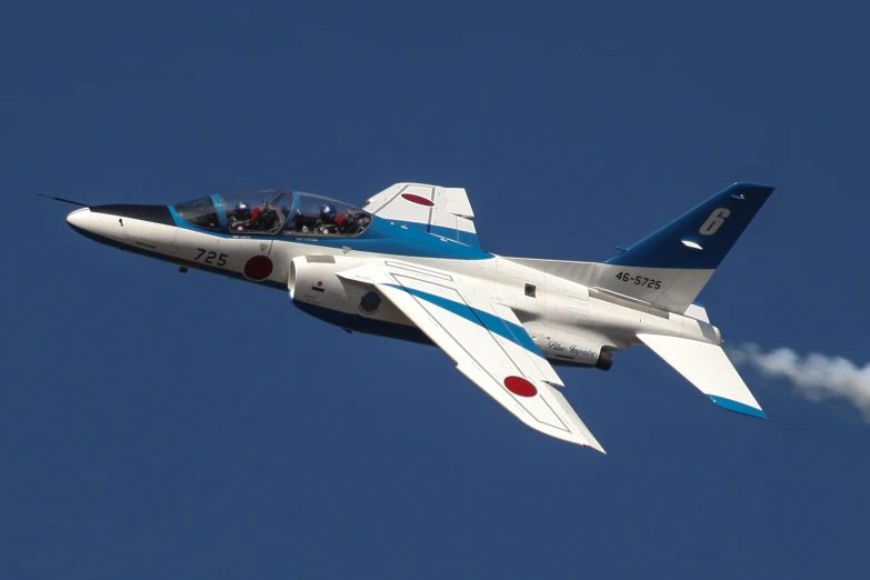 a fighter jet flying through a blue sky