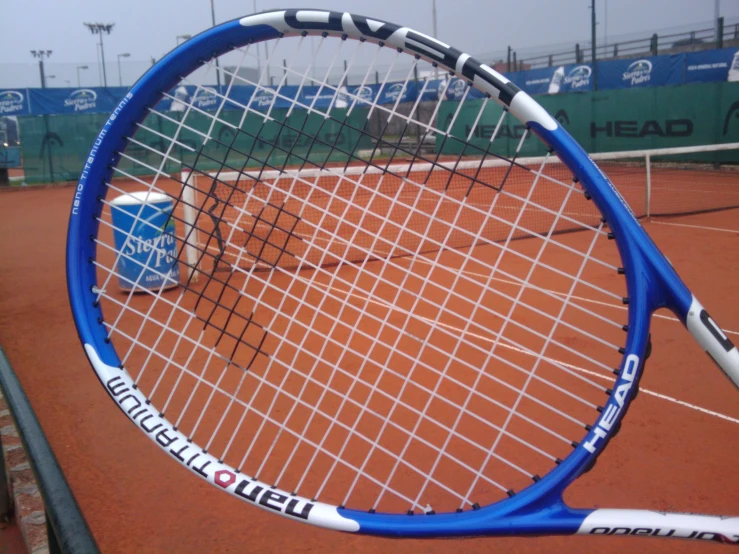 tennis racquets leaning up on a clay surface