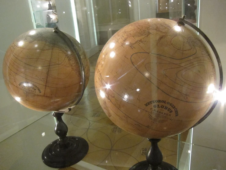 two small spherical glass vases with different size globes on it