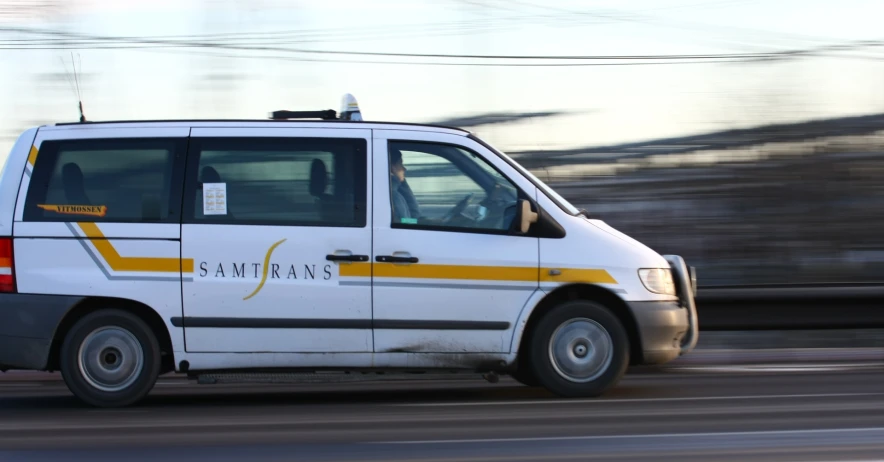 a white van driving down the street with soing on top