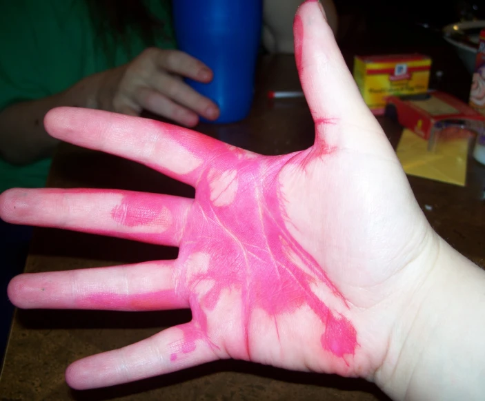 this is a person's hand with a pink substance on the palm