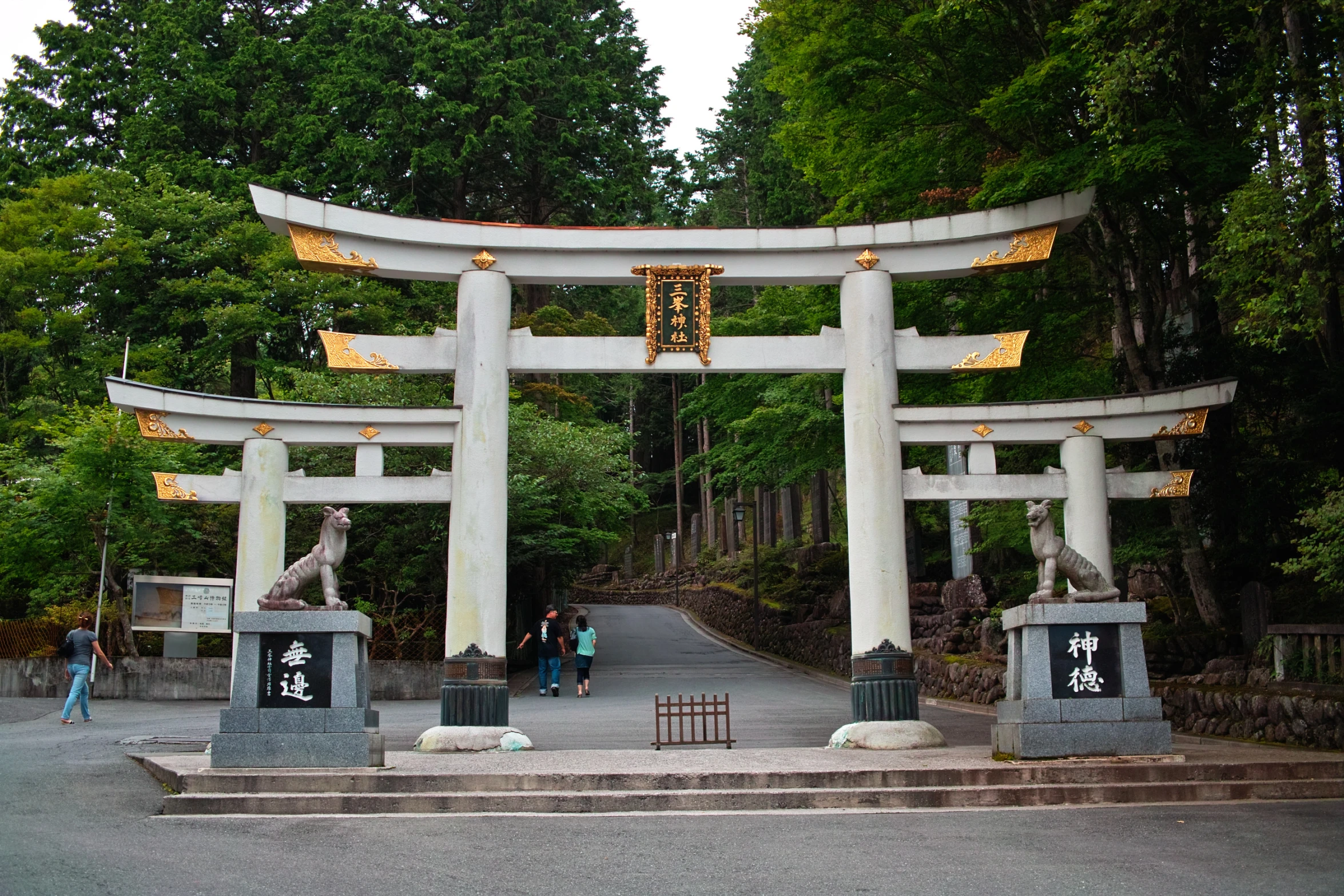 people walking through the gate to a shrine