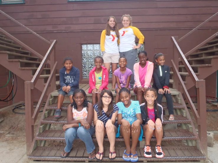 a group of s sitting on steps in front of a building