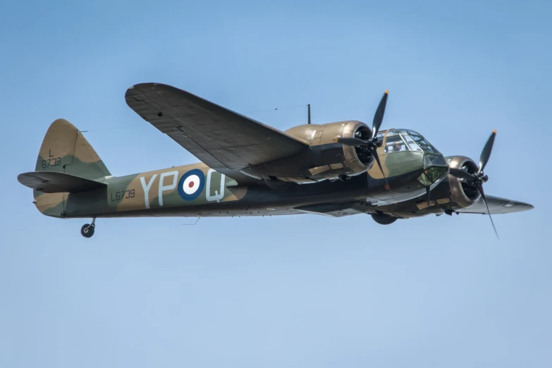 an old style airplane flying through the blue sky