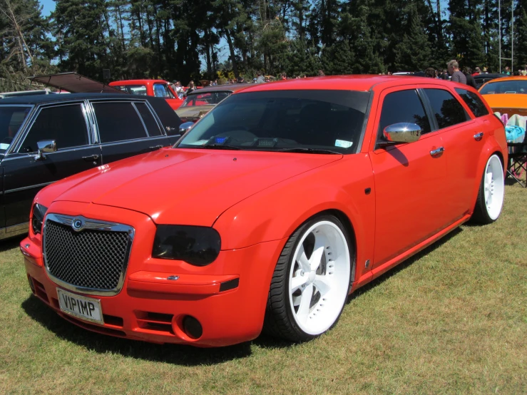 a red sports car is parked next to other cars