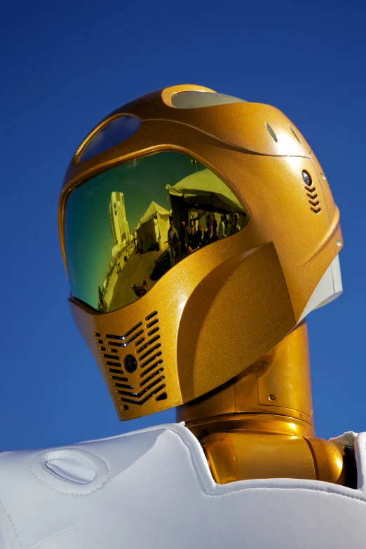 the helmet is gold in color and a po is reflected in it