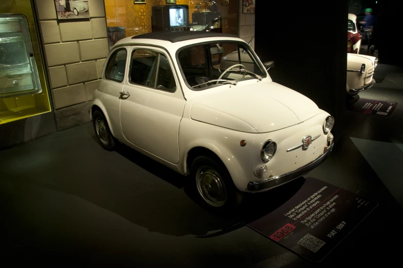 a white car sitting in front of a display case